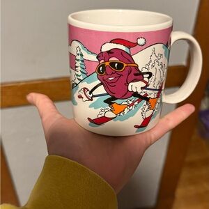 Vintage California Raisin wearing a Santa hat skiing down the slopes Mug